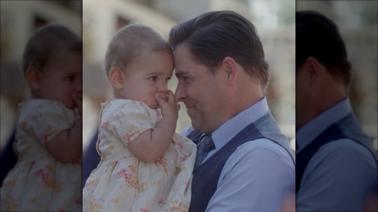 Kavan Smith holding a baby behind the scenes of "When Calls the Heart"