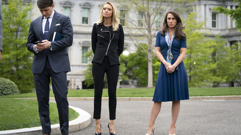 Kayleigh McEnany wearing black crop jeans standing with co-workers outside of the White House