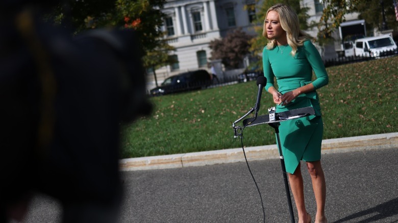 Kayleigh McEnany greeting reporters in a green dress.