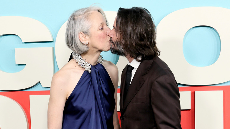 Keanu Reeves and Alexandra Grant kissing at a red carpet preimere