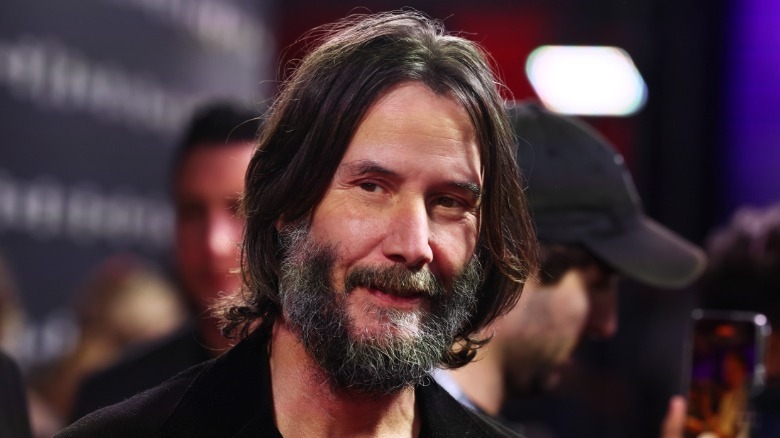 Keanu Reeves smiling with a full beard