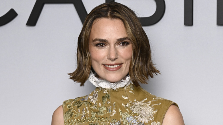 Keira Knightley smiling while posing on the red carpet