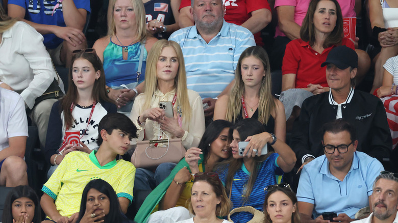 Nicole Kidman Keith Urban and their daughters sitting in bleachers during sporting event