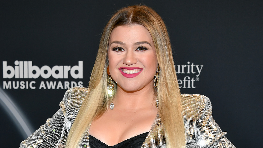 Singer Kelly Clarkson smiling in a bedazzled blazer 