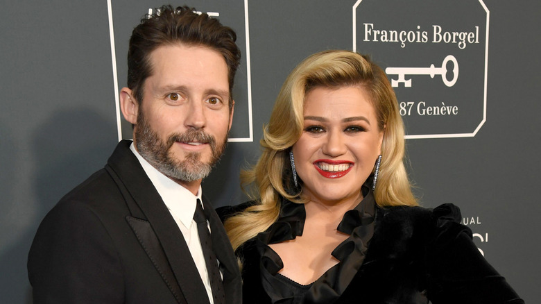 Brandon Blackstock and Kelly Clarkson pose for a photo at an event