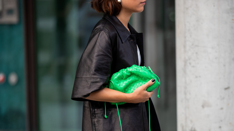 woman carrying green purse