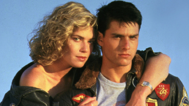 Kelly McGillis posing with her arm around a smoldering Tom Cruise on the set of 'Top Gun'