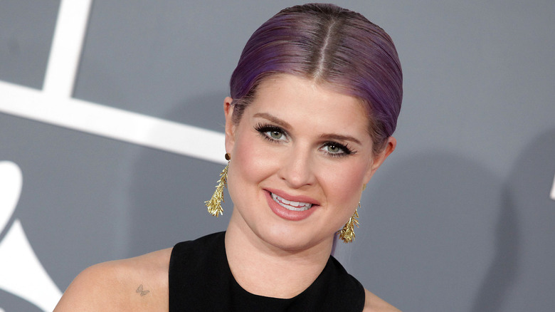 Kelly Osbourne with purple hair and gold earrings