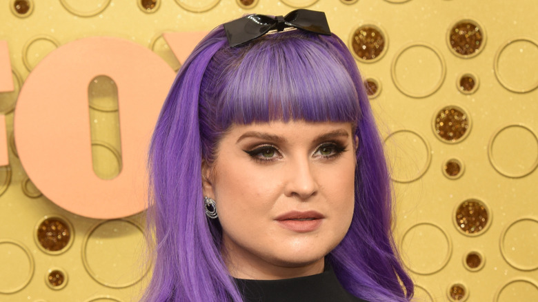 Kelly Osbourne with long purple hair and a bow in her hair
