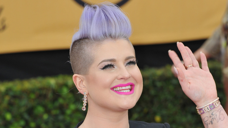 Kelly Osbourne with spiked blue hair and purple lipstick