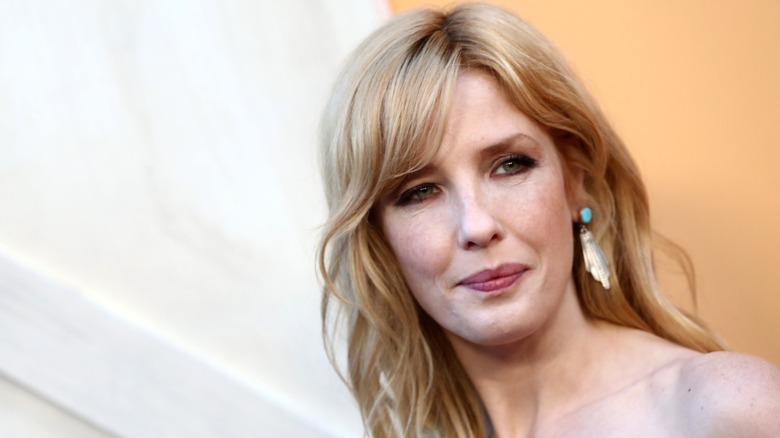 Kelly Reilly wearing a blue and feathery earring while posing at an event