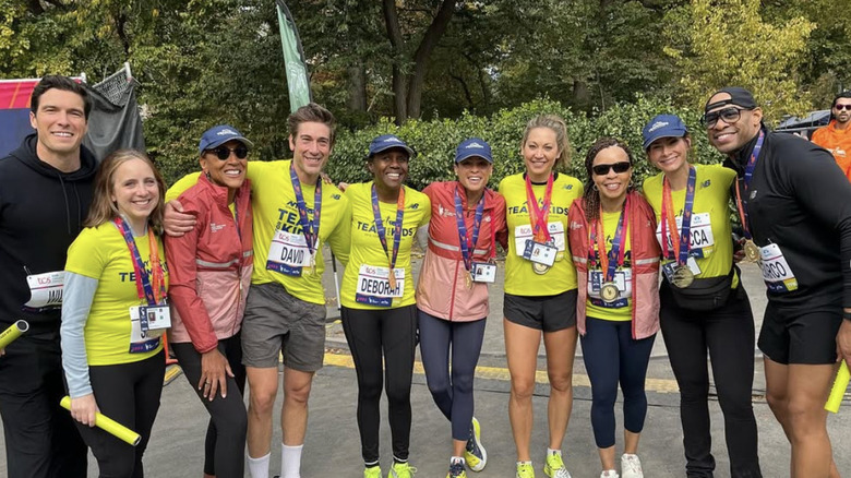 Robin Roberts, David Muir and Deborah Roberts surrounded by other members of ABC News