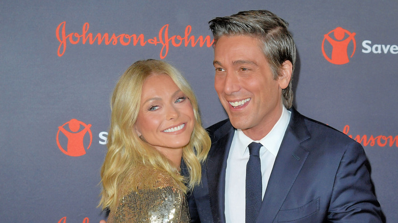 David Muir, right, with his arm around Kelly Ripa