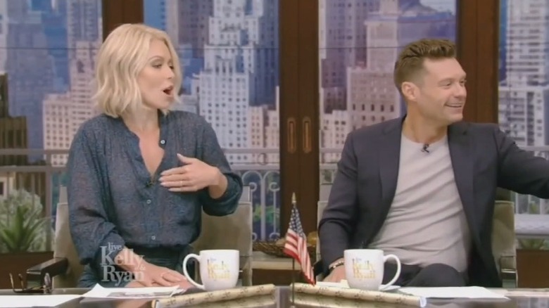 Kelly Ripa adjusting top on air