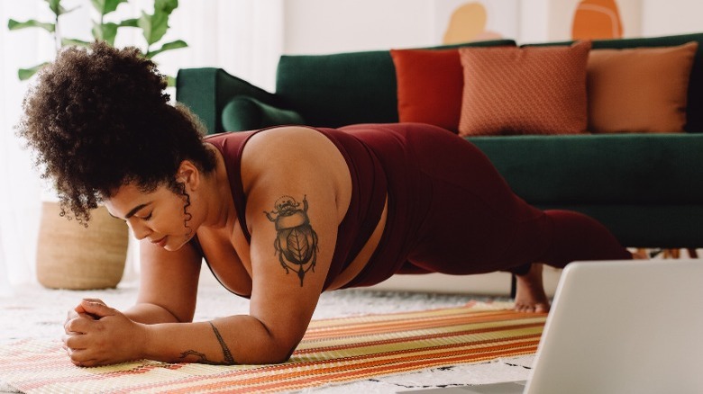 Woman doing plank exercise in living room