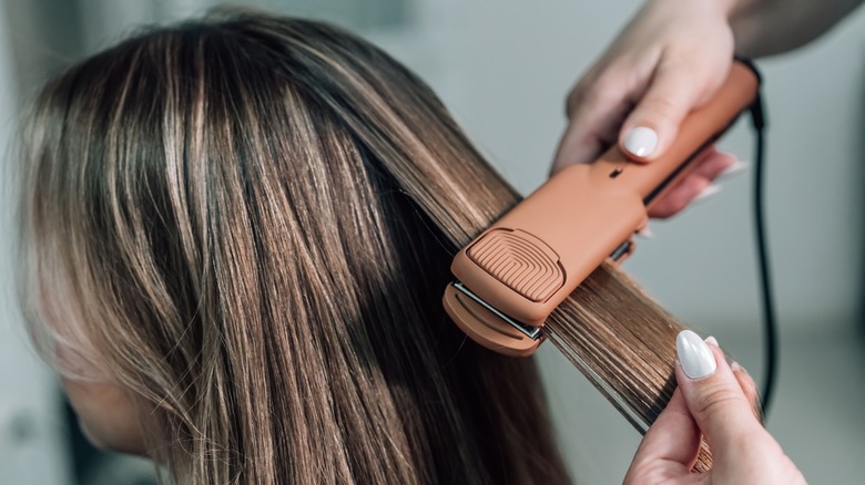 woman getting her hair straightened