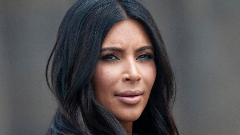 Kim Kardashian wears a brown coat.