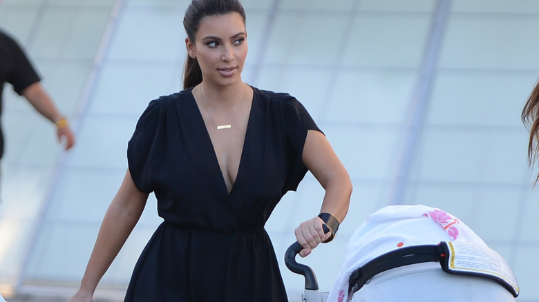 Kim Kardashian pushes a baby stroller.
