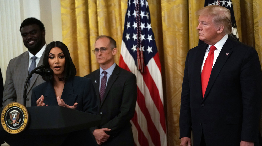 Kim Kardashian talking, Donald Trump watching