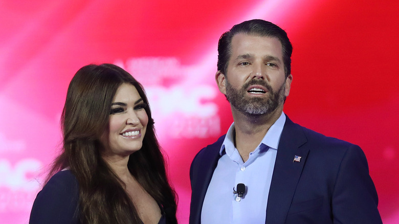 Kimberly Guilfoyle and Donald Trump smiling at each other while on stage.