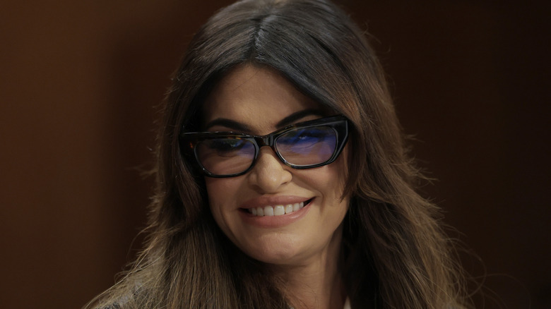 Kimberly Guilfoyle smiling while wearing glasses