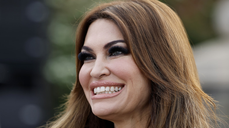 Kimberly Guilfoyle smiling while wearing pearls with her hair down