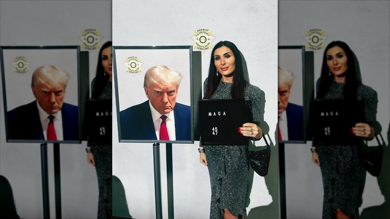Laura Loomer stands next to a photo of Donald Trump's mug shot