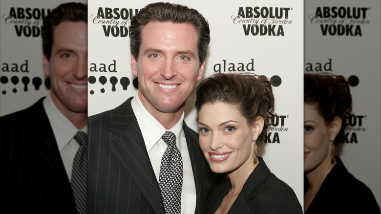 Kimberly Guilfoyle and Gavin Newsom smiling while posing together at an event