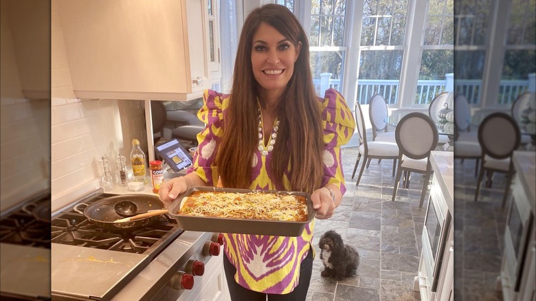 Kimberly Guilfoyle smiling and holding a lasagna
