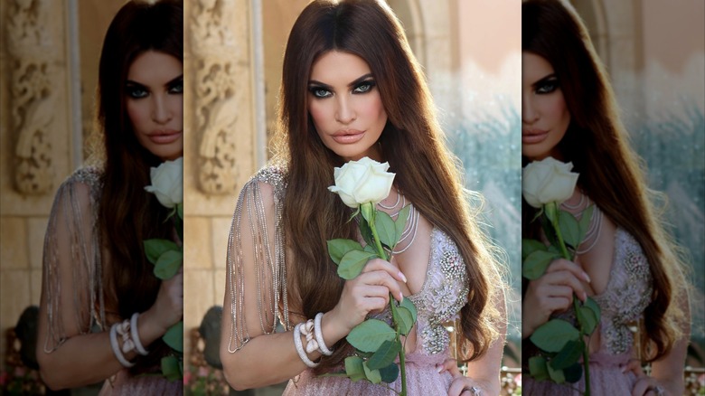 Kimberly Guilfoyle holds a single rose and poses for a photo in glam look