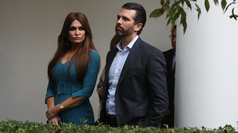 Kimberly Guilfoyle glaring at a bored-looking Donald Trump Jr.