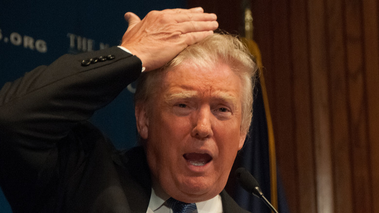 Donald Trump using his hand to push back his hair