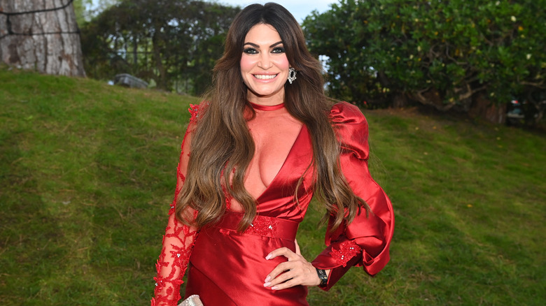 Kimberly Guilfoyle smiling for photos in a red outfit