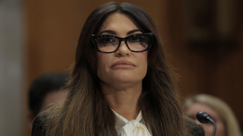 Kimberly Guilfoyle wearing glasses looking up