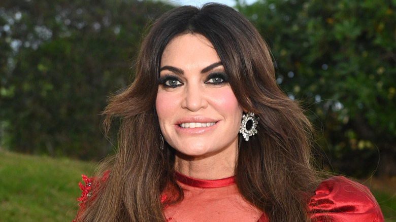 Close up of Kimberly Guilfoyle in a red lace dress with circular earrings.
