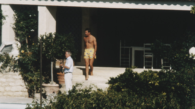 Young Prince Charles in swimming trunks on doorstep
