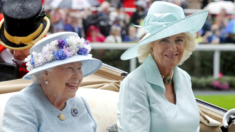 Queen Elizabeth and Camilla in carriage smiling