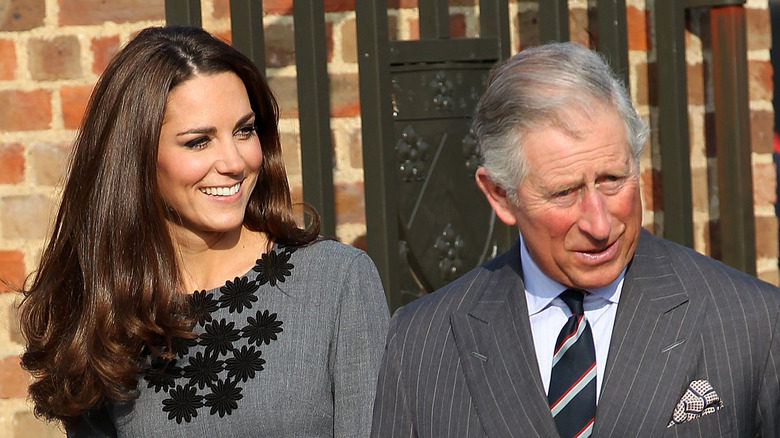 King Charles smiling at Kate Middleton standing together
