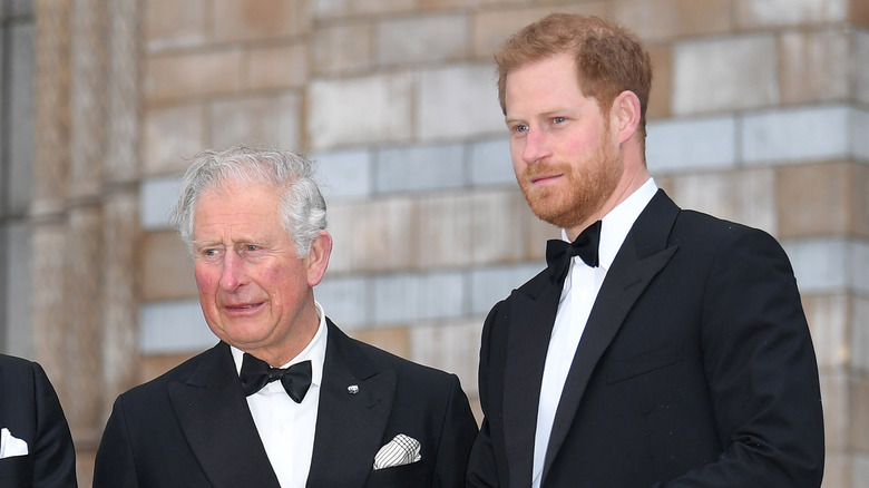 King Charles III and Prince Harry in tuxedos smiling