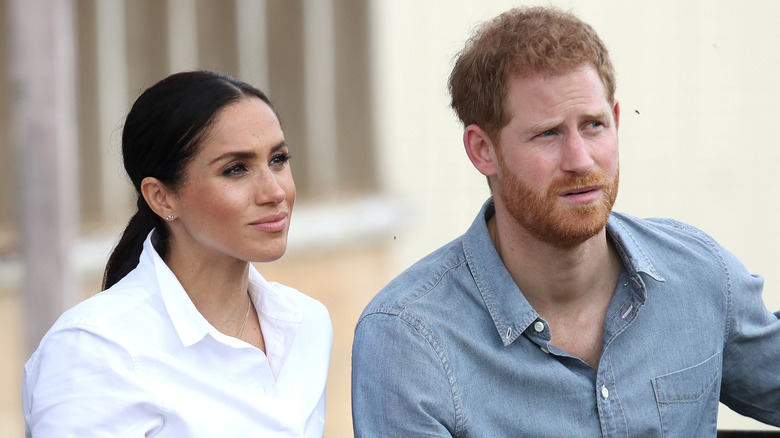 Prince Harry and Meghan Markle listening intently