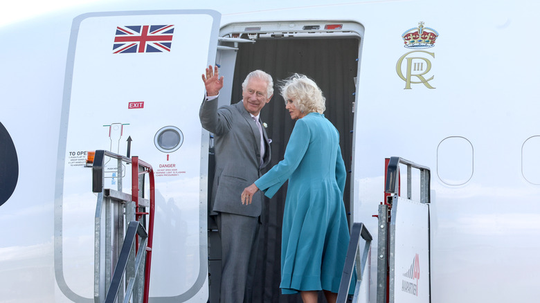 King Charles waving beside Queen Camilla 