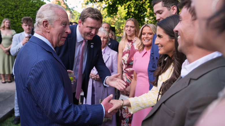 King Charles III shaking hands with Kaitlan Collins