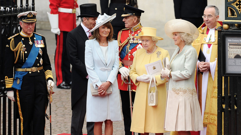 Prince Charles standing next to Michael Middleton, Carole Middleton, Prince Philip, Queen Elizabeth II, Camilla Parker Bowles, and a priest