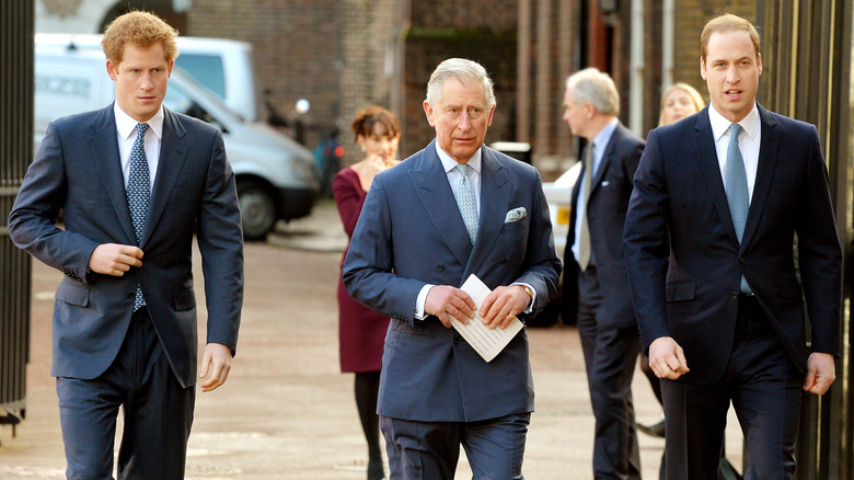 Prince Harry, King Charles, and William, Prince of Wales all walking together.