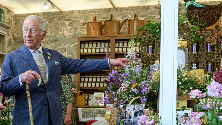 King Charles pointing at something in the Highgrove House garden shop
