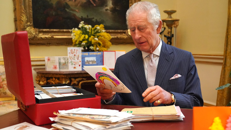 King Charles reading letters from his Red Box