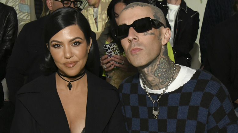 Kourtney Kardashian poses at an event alongside Travis Barker