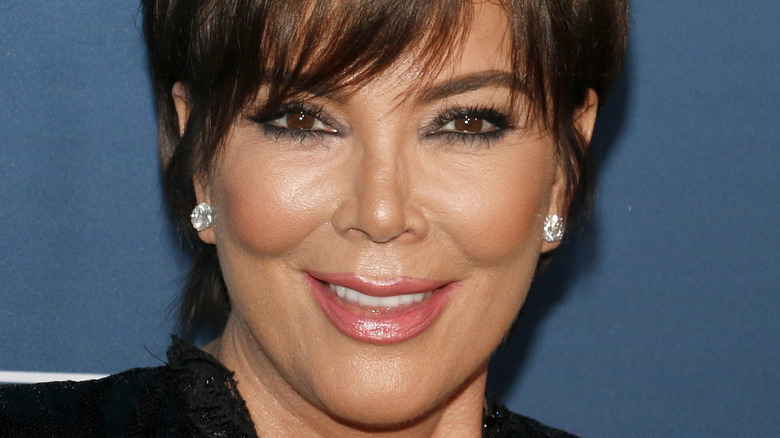 Kris Jenner laughing on red carpet with diamond earrings