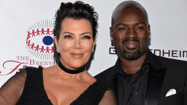In a close-up, Kris Jenner and Corey Gamble smile while wearing black.