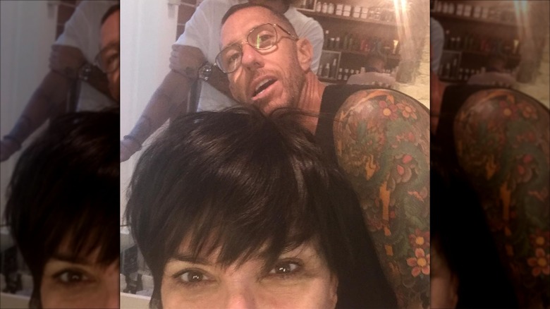 Kris Jenner posing with only her eyes up visible and Chris McMillan behind her.